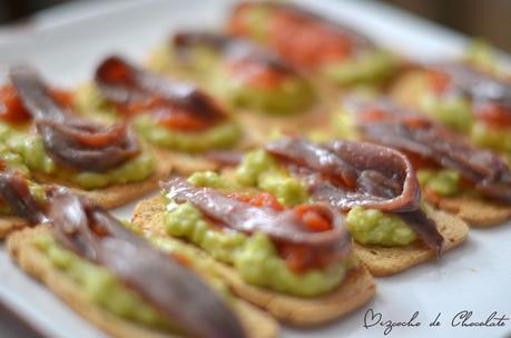 Tosta de guacamole, tomate y anchoas.