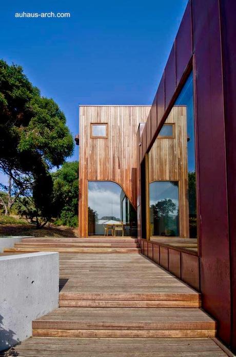 Casa orgánica rústica de concreto, madera y metal.