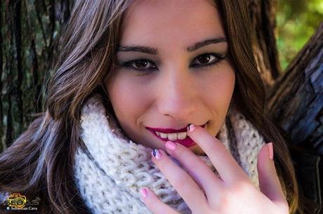 Retrato de chica maquillada con uñas decoradas en bosque y parque