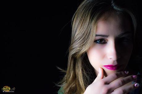 Chica maquillada con sombra en media cara y fondo blanco