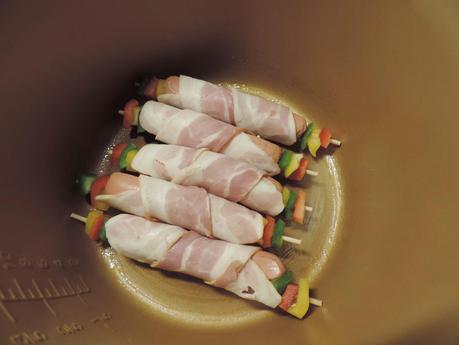 Brochetas de salchichas de pollo, bacon, pimiento y queso con arroz blanco.