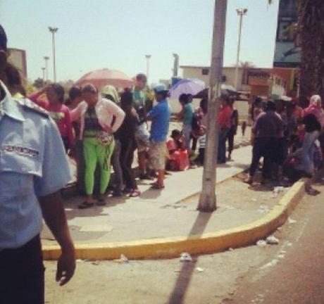 27 de enero, Maracaibo.  I Quisiera que esto no me afectara. Pasar de largo. Sin inmutarme. Quisiera no mirar. No ver a esas mujeres con la teta expuesta en la calle y el niño de meses pegado. Quisiera no sentir este desconsuelo. ¡Son las 12 del día! ¡Hacen 40 grados a la sombra! No quiero ver a esas criaturas mamando mientras les tratan de comprar UN paquete de pañales. Con suerte, UNA fórmula láctea. Pero no hay cómo no verlos. Están por toda la ciudad. Por el país. Tomo la foto. No me acostumbro. Algo duele adentro. II A veces, en mis ratos de ocio. Entre la salida de un cliente y la colecta del mojón de Toya. Mientras Charlie ronronea se funde en mi papada, Pienso. Sueño. Imagino la vida en otros sitios. Allá, donde el último litro de leche en la nevera no estresa. Al día siguiente, se repone. Y la azucarera nunca está vacía. En la calle, la gente tiene ojos. Las mujeres tienen culo. Tetas Los hombres tienen 'paquete'. No son una bolsa que flota. Y los amigos se reúnen Las conversas son sobre la película de anoche. El libro que compraron. La obra de teatro que verán. Sin pensar ni preguntar ¿Dónde conseguiste pañales? ¿Sacaron leche? ¿Cuántas dejan comprar? ¡Necesito una batería! Un muerto por robo escandaliza Moviliza. Traumatiza. No es 