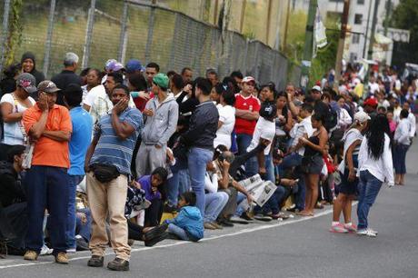 People line up outside a state-run Bicentenario supermarket in Caracas