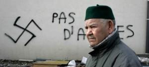 Un ciudadano francés pasa por delante de una pintada islamófoba en una mezquita en Sant-Etienne, en 2010/ GTRES