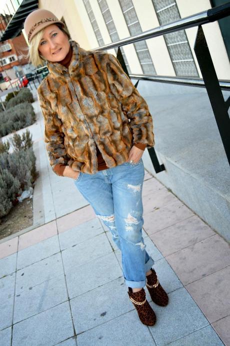 Fluffy coat, animal print and ripped jeans. Retro hat.