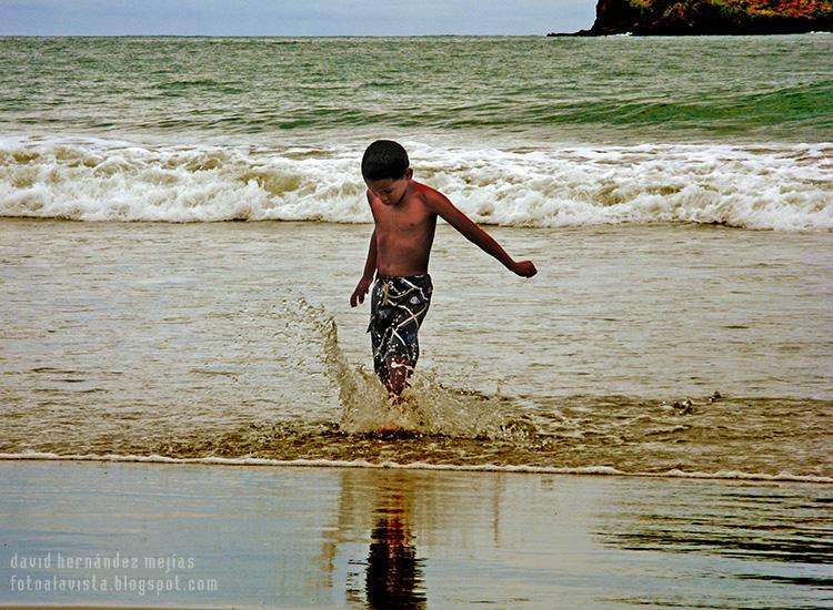 Niño en el mar chapoteando y salpicando agua