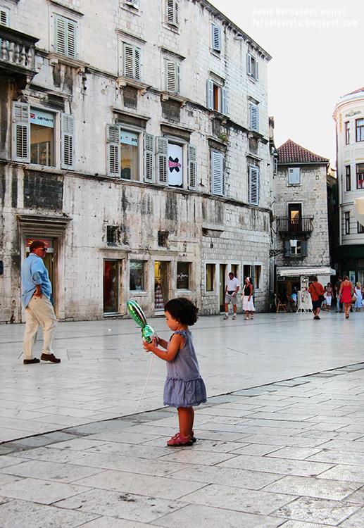 Una niña con un globo en las manos en las calles de Split