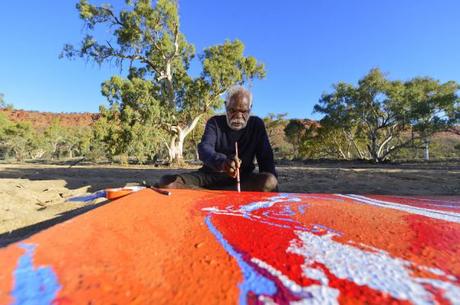 Yannima Tommy Watson paints in his country near Alice Springs