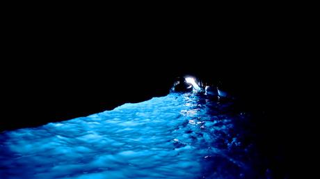 phosphorescent blue glow against pitch black sea cave