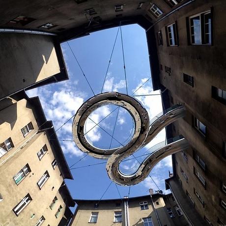 Pasarela verde flotando en el aire conecta dos oficinas