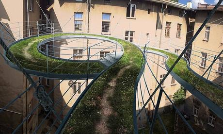 Pasarela verde flotando en el aire conecta dos oficinas