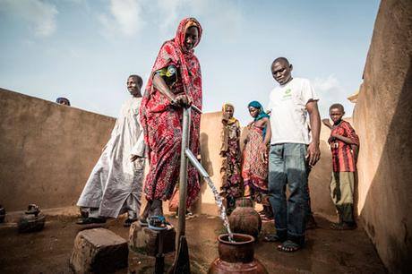 Akkoe Moussa, echando agua en un cántaro de cerámica junto a otras personas. Tiene entre 45 y 50 años y vive en Madoul, cerca de Mangalmé. En este pueblo hay dos puntos de agua limpia, y sus habitantes trabajan para mantener la higiene comunitaria.  (Foto: Pablo Tosco, cortesía de Intermón Oxfam)
