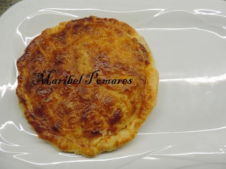 Empanada de hojaldre con salchichas de pollo, cebolla y queso de cabra.