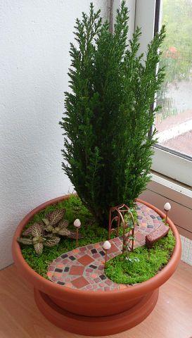 fairy gardens or miniature gardens can be made just about anywhere. Great use of a conifer to bring it all together