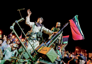 Manifestantes en contra de Gadafi, portando la bandera monárquica del anterior gobernante, Idris I