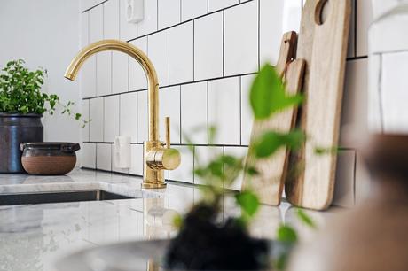 UNA COCINA GRIS CON DETALLES DORADOS