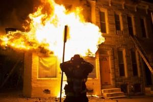 Bomberos acuden a extinguir las llamas en un edificio durante los disturbios provocados durante una protesta contra la muerte de Freddie Gray en Baltimore (Estados Unidos). (John Taggart / EFE)