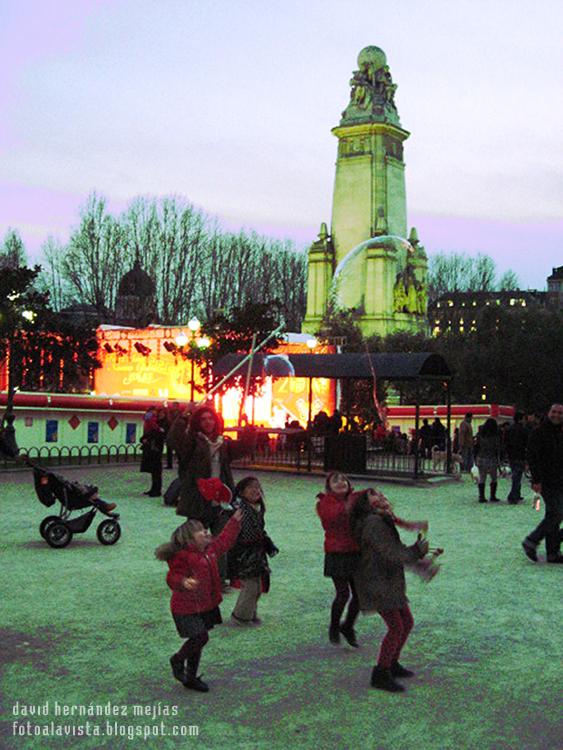 Unas niñas saltan a coger enormes pompas de jabón en la Plaza de España de Madrid