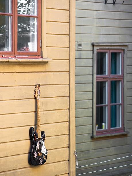 PIEZAS VINTAGE DE MADERA Y UNA GUITARRA COLGADA EN LA FACHADA