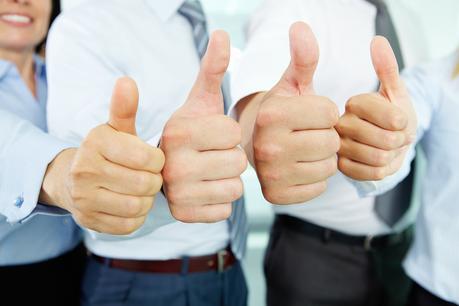 Close-up of business team holding their thumbs up