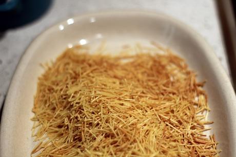 Conejo con fideos, habas y guisantes frescos