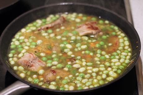 Conejo con fideos, habas y guisantes frescos
