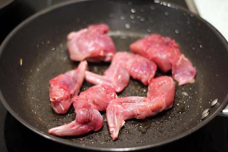 Conejo con fideos, habas y guisantes frescos