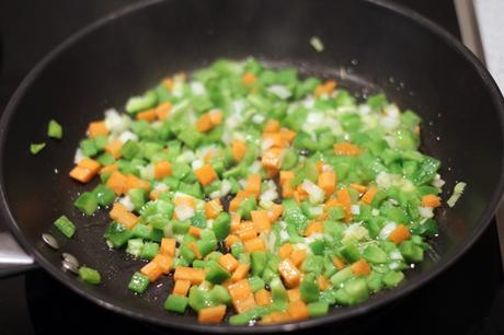 Conejo con fideos, habas y guisantes frescos
