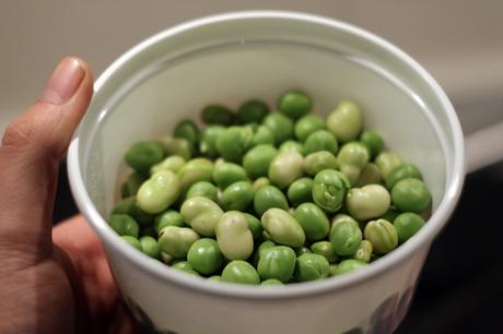 Conejo con fideos, habas y guisantes frescos