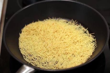 Conejo con fideos, habas y guisantes frescos