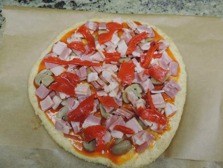 Pizza de masa integral de jamón york, bacon, champiñon, pimientos de piquillo y queso.