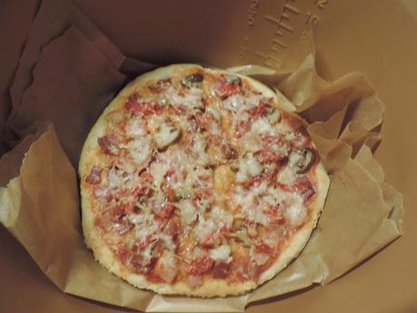 Pizza de masa integral de jamón york, bacon, champiñon, pimientos de piquillo y queso.