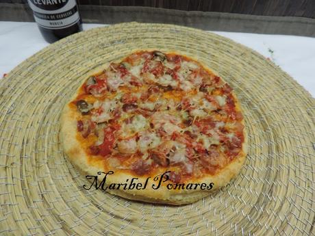 Pizza de masa integral de jamón york, bacon, champiñon, pimientos de piquillo y queso.