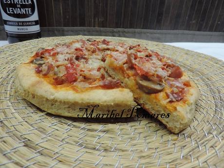 Pizza de masa integral de jamón york, bacon, champiñon, pimientos de piquillo y queso.