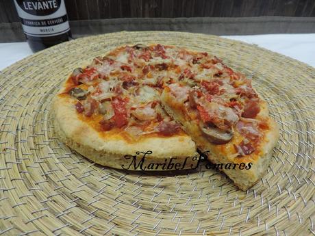 Pizza de masa integral de jamón york, bacon, champiñon, pimientos de piquillo y queso.