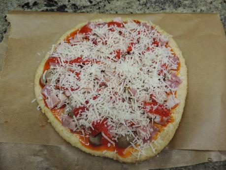 Pizza de masa integral de jamón york, bacon, champiñon, pimientos de piquillo y queso.