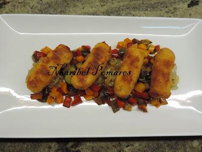 Salchichas empanadas con pan rallado con queso, ajo y perejil, con acompañamiento de cebolla, calabacin y pimientos a la planchas.