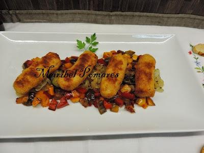 Salchichas empanadas con pan rallado con queso, ajo y perejil, con acompañamiento de cebolla, calabacin y pimientos a la planchas.