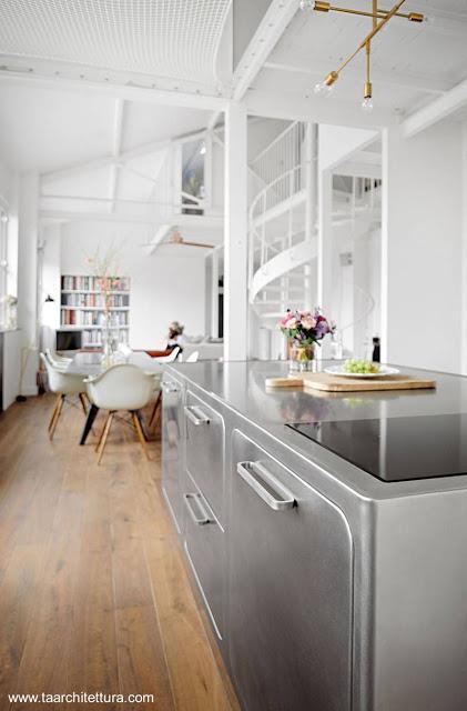 Cocina moderna integral de acero inoxidable en un loft de París.