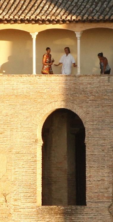U.S. first lady Michelle Obama (L) listens to an unidentified man during her visit to the Alhambra Palace in the southern Spanish town of Granada August 5, 2010. BEST QUALITY AVAILABLE  REUTERS/Jon Nazca (SPAIN - Tags: POLITICS)