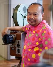 Rithy Panh detrás de cámara. El muñequito de arcilla que lo representa lleva la misma chomba a colores.