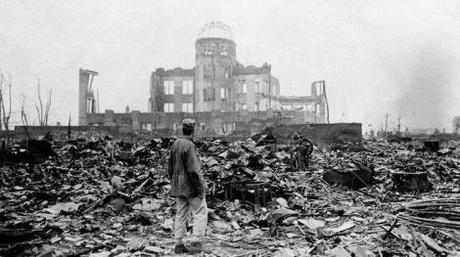 FILE - In this Sept. 8, 1945 file photo, an allied correspondent stands in the rubble in front of the shell of a building that once was a exhibition center and government office  in Hiroshima, Japan, a month after the first atomic bomb ever used in warfare was dropped by the U.S. on Aug. 6, 1945. (AP Photo/Stanley Troutman, File)