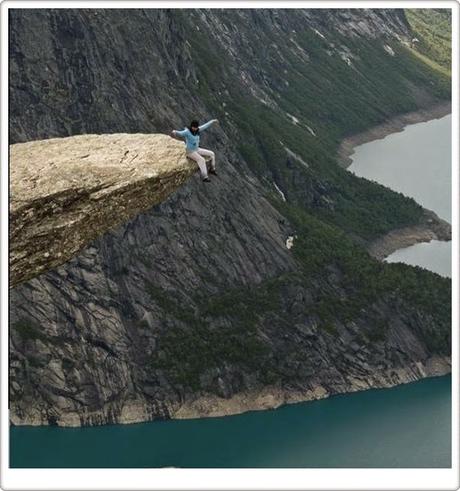 Sentarse en la roca Trolltunga de Noruega.