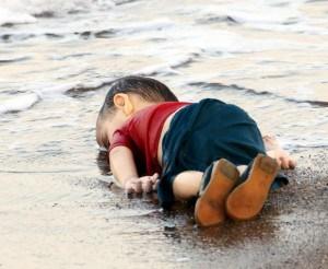 A young migrant, who drowned in a failed attempt to sail to the Greek island of Kos, lies on the shore in the Turkish coastal town of Bodrum