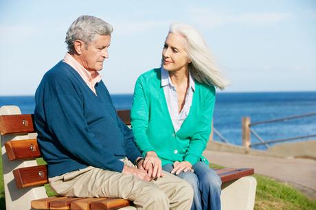 Senior Woman Comforting Depressed Husband Sitting On Bench