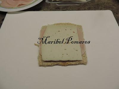 Flamenquines de pan bimbo, jamón york y queso con rebozado de pan rallado con queso, ajo y perejil.