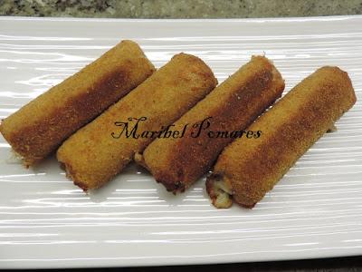 Flamenquines de pan bimbo, jamón york y queso con rebozado de pan rallado con queso, ajo y perejil.