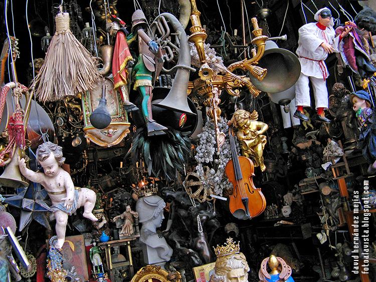 Pequeños y medianos objetos de todo tipo colgados de forma abigarrada en una tienda de Nápoles