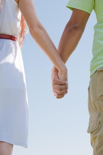 closeup image of a young couple holding hands