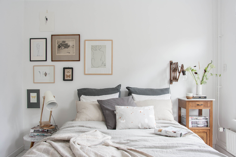 Decoracion-dormitorio-composicion-de-cuadros-en-tonalidades-grises-y-marrones-mesita-de-noche-vintage